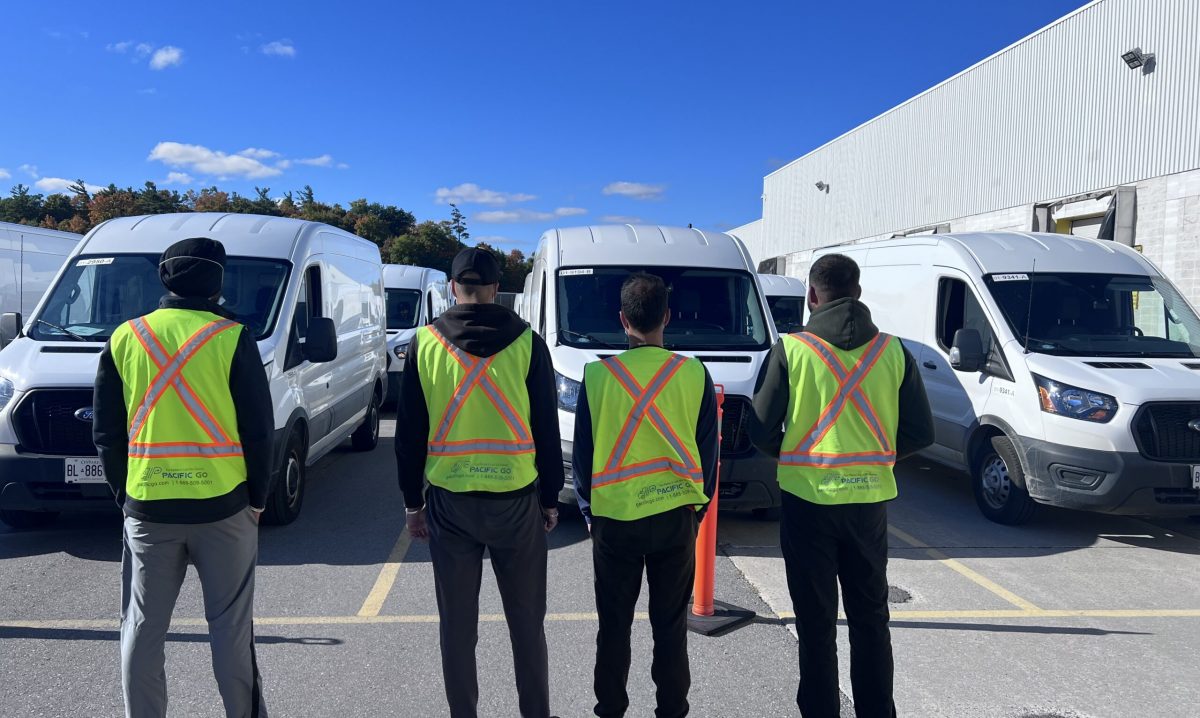 6 Pacific Go employees in front of delivery vans